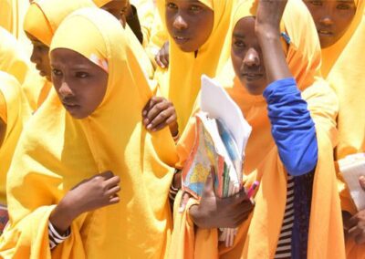 School girls in bright yellow hijabs carrying school books