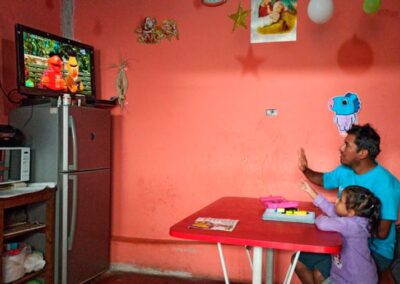 Father and daughter home learning and interacting with tv lesson with Sesame Street characters