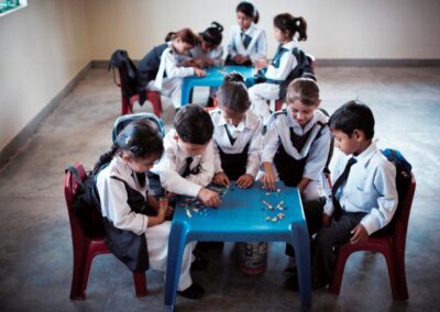 primary age children sitting around two tables making patterns with crayons