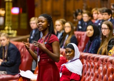 Young black woman standing and speaking among other school children