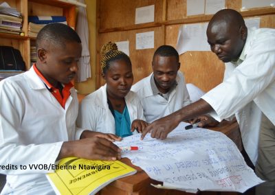 Rwandan mentor and teachers looking at learning materials