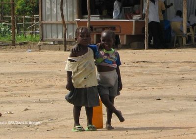 Two young girls in front of a building in South Sudan