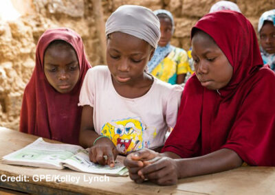 Three Girls looking at a book in a classroom in Niger