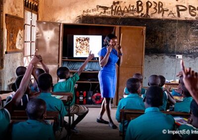 teacher in classroom with students with their hands up