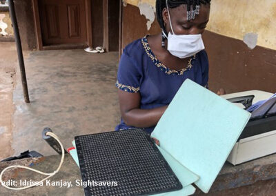 Girl typing braille notes during a radio lesson