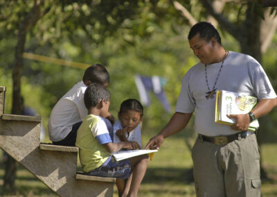 Teacher and student with book under a tree