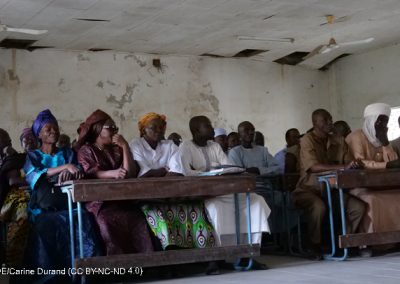 Adults sittiing in a row behind desks