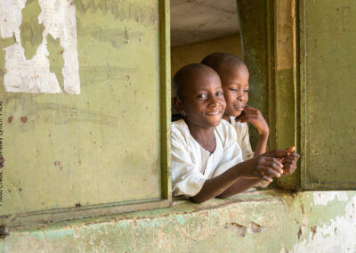 Two Boys looking out of a window smiling