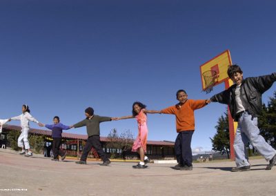 Children holding hands with their arm outstretched in a line