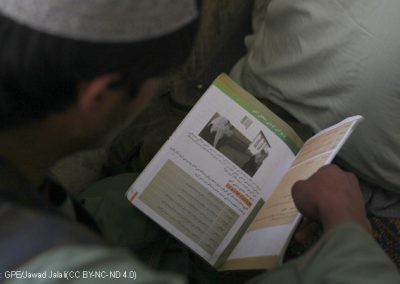 An Afghan boy reading a text book