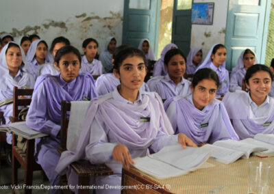 A class of girls in lilac coloured uniform sitting at desks with text books open