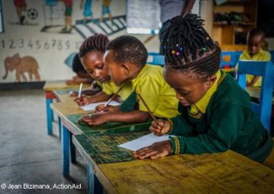 Primary School children wearing green and mustard uniform in a classroom in Rwanda