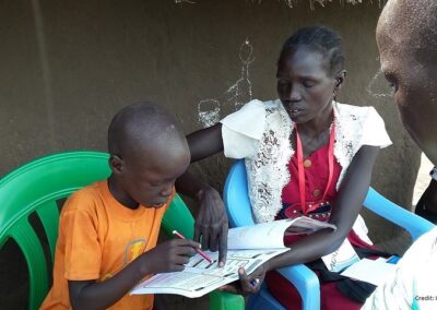 South Sudanese volunteers assess a child's reading