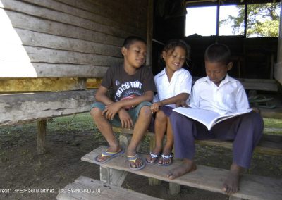 Two boys and a girl reading on a step, Honduras