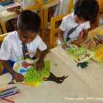 Two primary school children colouring in class, Sri Lanka.