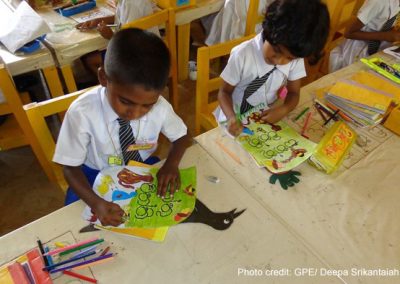 Two primary school children colouring in class, Sri Lanka.