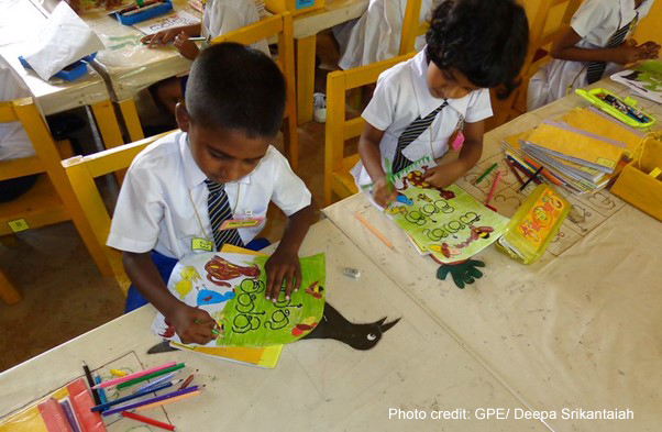 Two primary school children colouring in class, Sri Lanka.