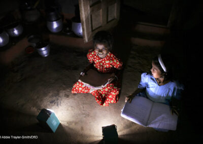 Two girls study by solar light at night in Tinginaput, rural Orissa, India