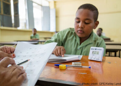 A student identifies letters during a national learning assessment, Sudan.
