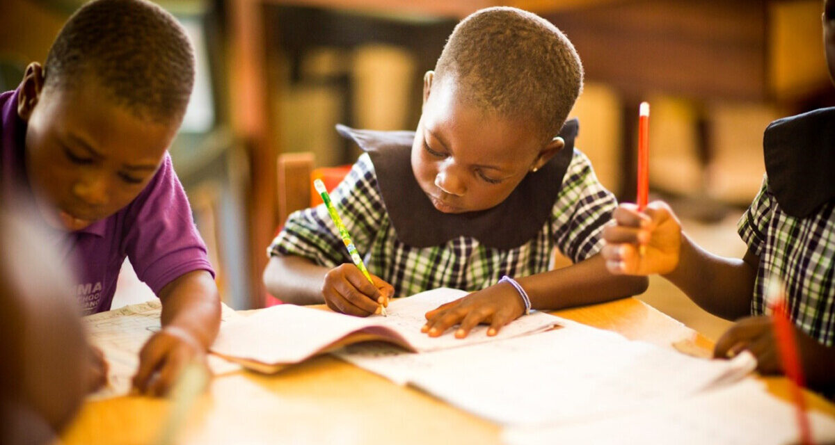 Young children learn writing at their desk in a primary school, Ghana.