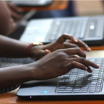 Hands typing on a laptop keyboard