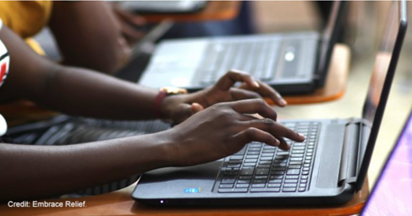 Hands typing on a laptop keyboard