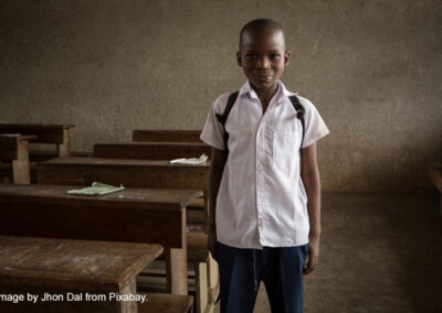 Young boy stands next to his desk on his first day back to school.