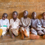 A group of boys sit on the floor leaning against the wall during a lesson at their primary school in Roni, Jigawa State, Nigeria.