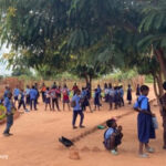 Children playing outside a community school, awaiting the next ‘shift’.