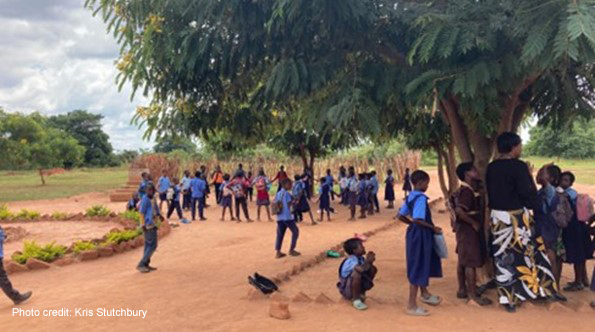 Children playing outside a community school, awaiting the next ‘shift’.