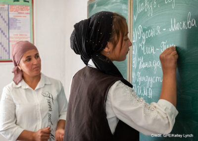 Female teacher and student at the blackboard in a classroom, Dangara Tajikistan.