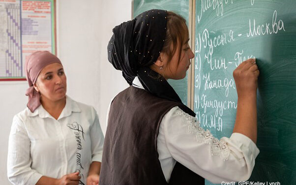 Female teacher and student at the blackboard in a classroom, Dangara Tajikistan.