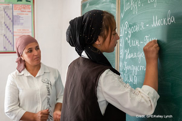 Female teacher and student at the blackboard in a classroom, Dangara Tajikistan.