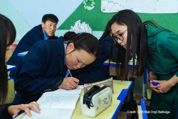 17-year-old deaf student concentrates during a language lesson, Mongolia. Her teacher is watching