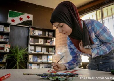 Woman painting on a table in a library, Aleppo