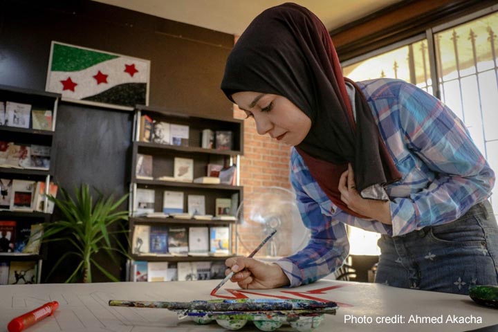 Woman painting on a table in a library, Aleppo