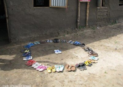 Shoes in a circle outside school with one pair in the middle. Students and teacher leave their shoes outside the door to keep the class clean. Gudele West Basic School, outside Juba, South Sudan.