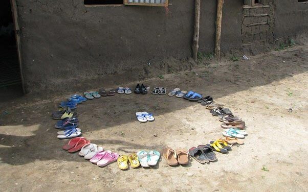 Shoes in a circle outside school with one pair in the middle. Students and teacher leave their shoes outside the door to keep the class clean. Gudele West Basic School, outside Juba, South Sudan.