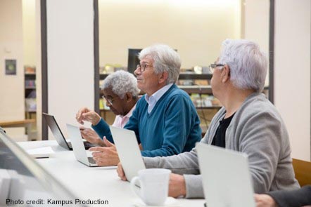 Three older people in a computer class, Portugal.